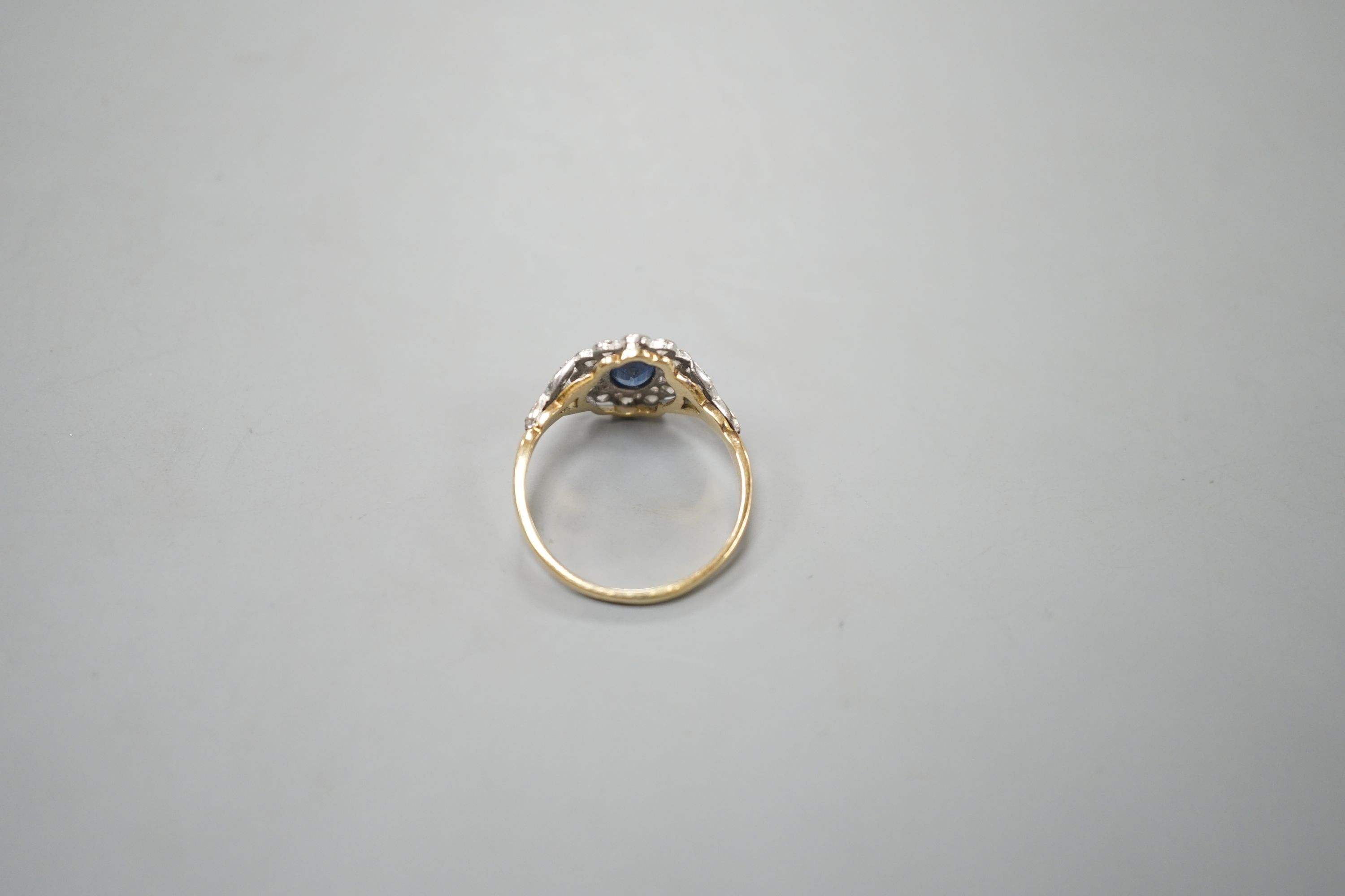 A yellow metal, sapphire and diamond set oval cluster ring, size T, gross weight 3.8 grams.
